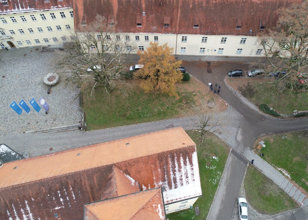 Aerial photograph of a campus with roofs, access roads and parking areas