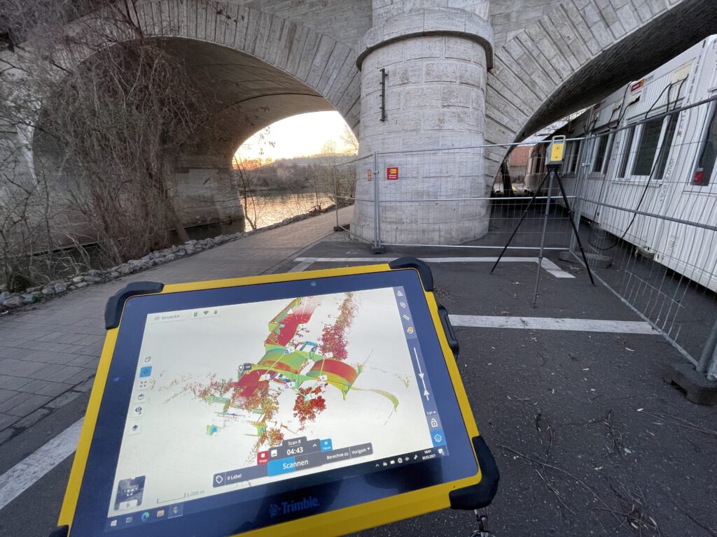 Tablet showing a coloured point cloud while surveying a road underpass