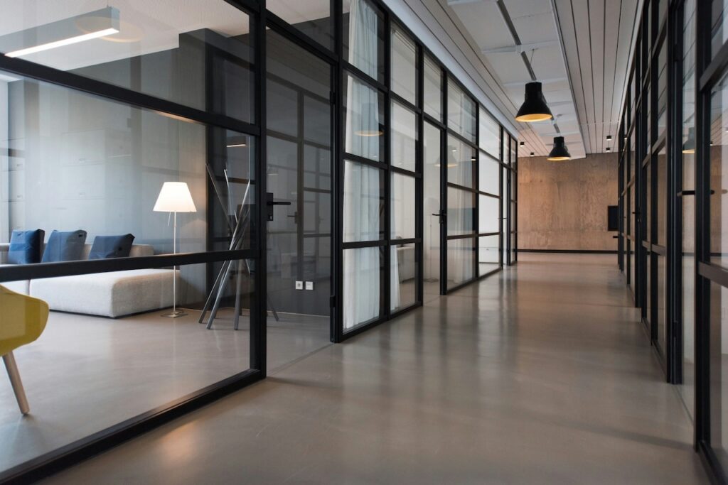 Empty office floor with glass partitions and a long circulation corridor